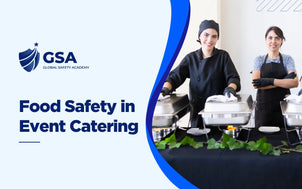 Global Safety Academy Food Safety in Event Catering training banner showing two female caterers wearing black aprons and gloves setting up chafing dishes at a buffet